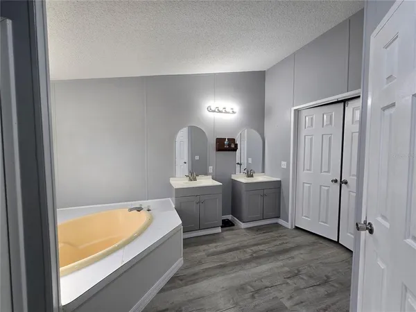 a bathroom with a tub sink and mirror
