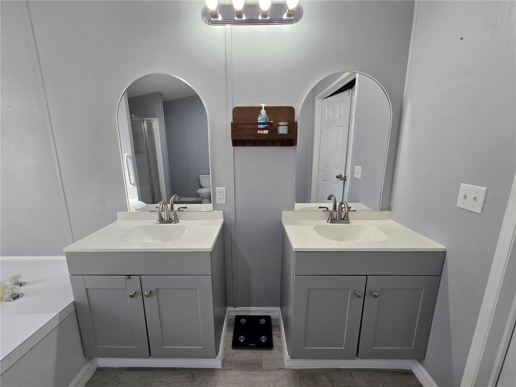 55921 Fern Road Astor, FL 32102 - Photo 13 of 24 a bathroom with a double vanity sink and a mirror