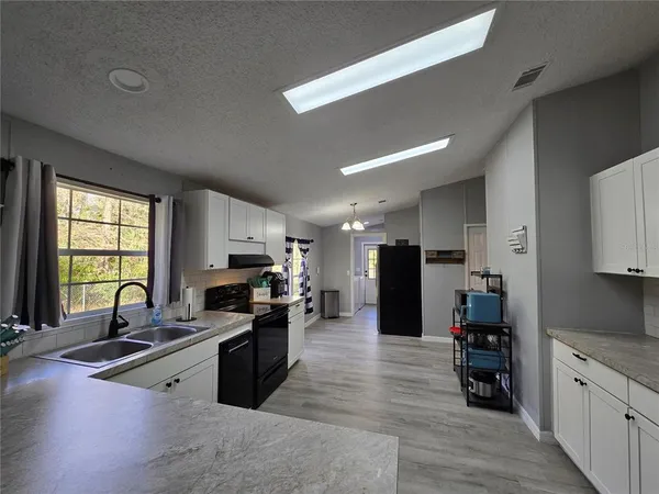 a open kitchen with stainless steel appliances granite countertop a refrigerator stove top oven and sink