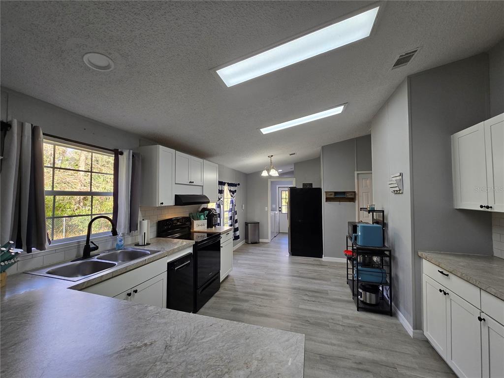 55921 Fern Road Astor, FL 32102 - Photo 5 of 24 a open kitchen with stainless steel appliances granite countertop a refrigerator stove top oven and sink