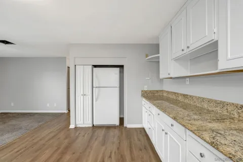 a kitchen with granite countertop white cabinets and sink