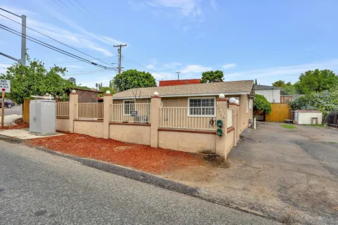a view of a white house with a yard and potted plants