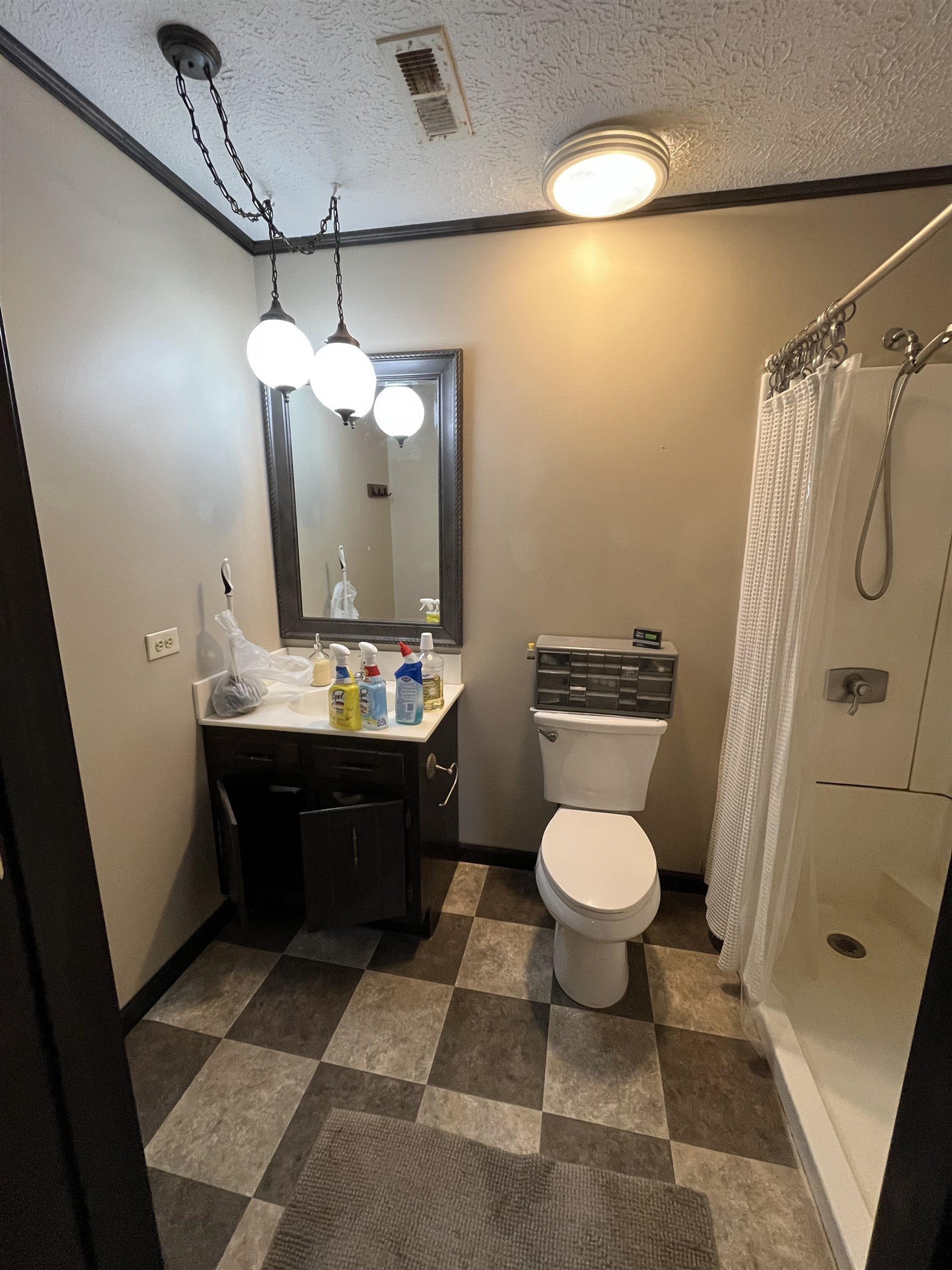 1125 Tyson Road Toone, TN 38381 - Photo 12 of 12 Bathroom with checkerboard floor tile, single vanity with integrated sink, framed mirror, and a shower stall