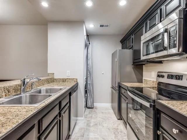 8601 Park Lane, Unit 721 Dallas, TX 75231 - Photo 3 of 5 a kitchen that has a sink and a stove