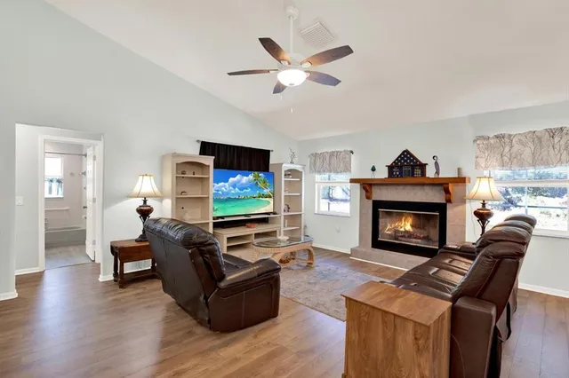 a living room with furniture a fireplace and a flat screen tv