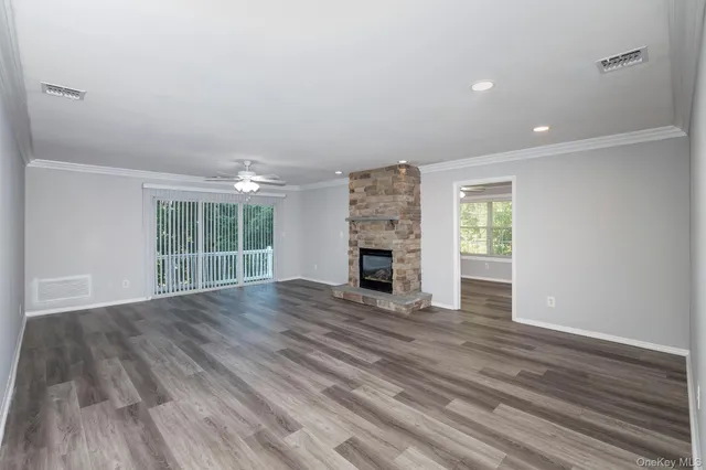wooden floor fireplace and windows in an empty room