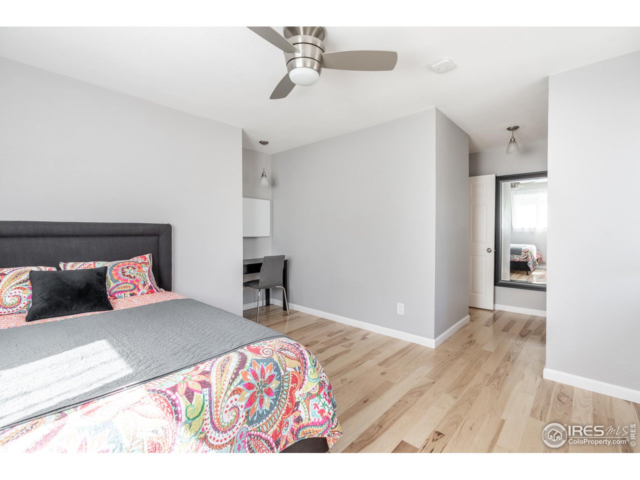 7357 Glacier View Road Longmont, CO 80503 - Photo 25 of 39 a bedroom with a bed and wooden floor