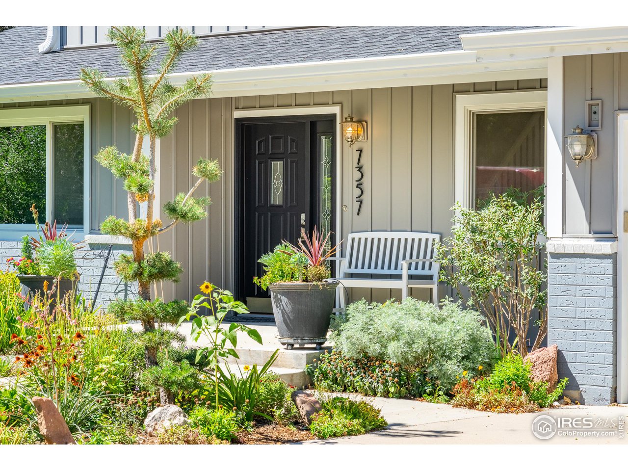 7357 Glacier View Road Longmont, CO 80503 - Photo 3 of 39 a front view of a house with a lots of flower garden