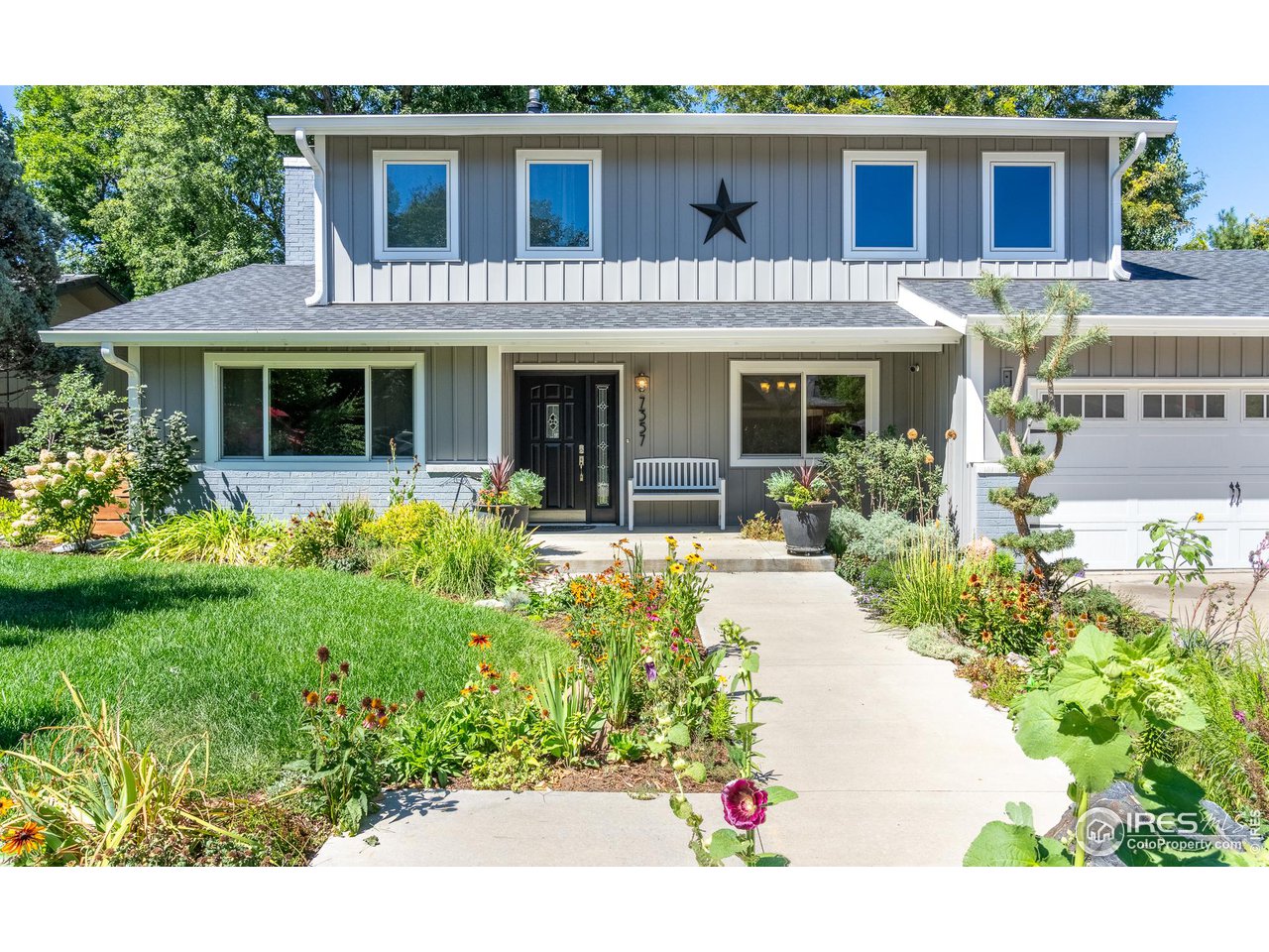7357 Glacier View Road Longmont, CO 80503 - Photo 5 of 39 a front view of a house with a yard and potted plants