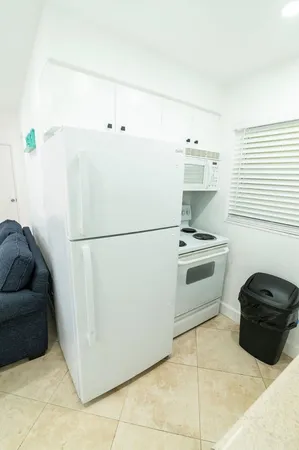 a white refrigerator freezer and a stove sitting inside of a kitchen