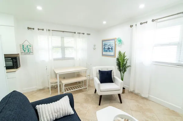 a living room with furniture a flat screen tv and a window