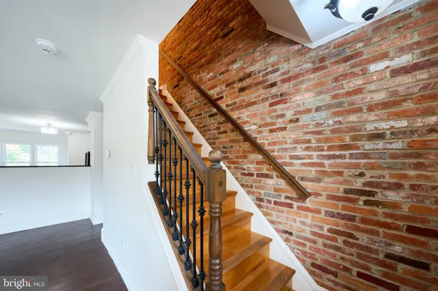 a view of a livingroom with wooden floor and a hallway