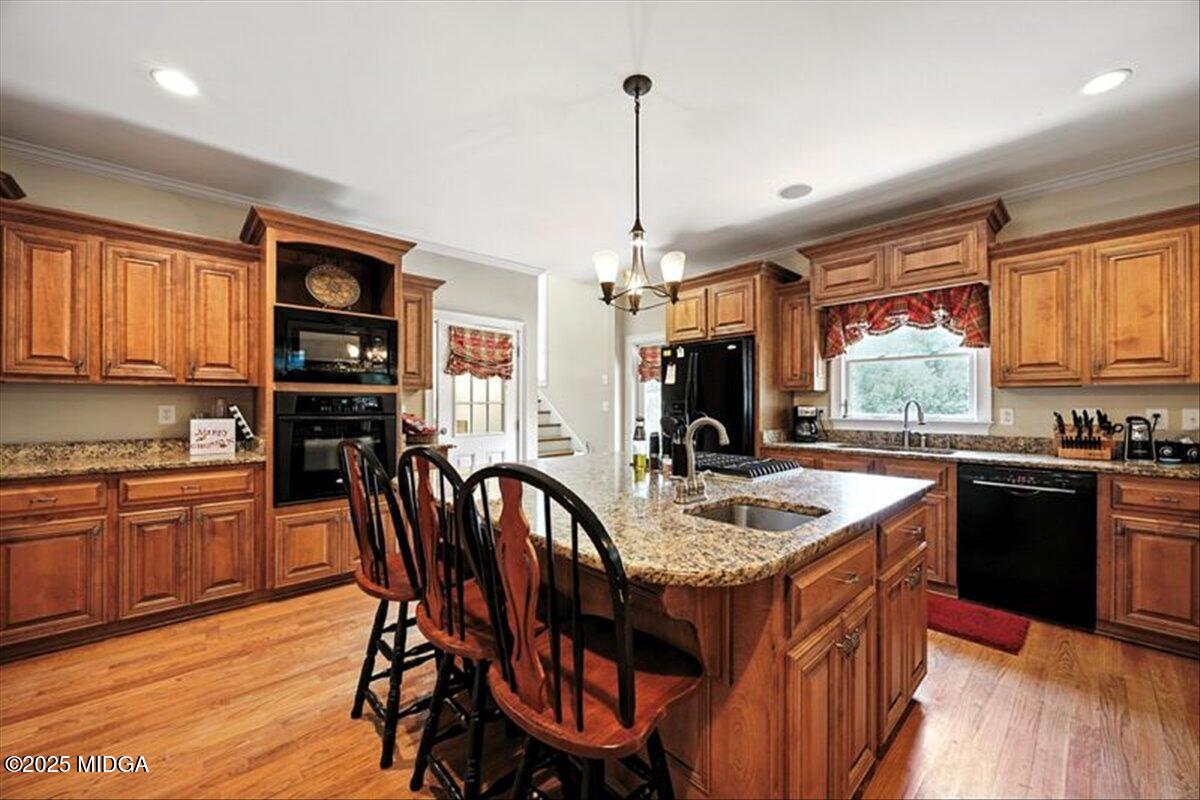 625 Rum Creek Road Juliette, GA 31046 - Photo 40 of 81 a kitchen with stainless steel appliances granite countertop a stove a sink dishwasher a dining table and chairs with wooden floor
