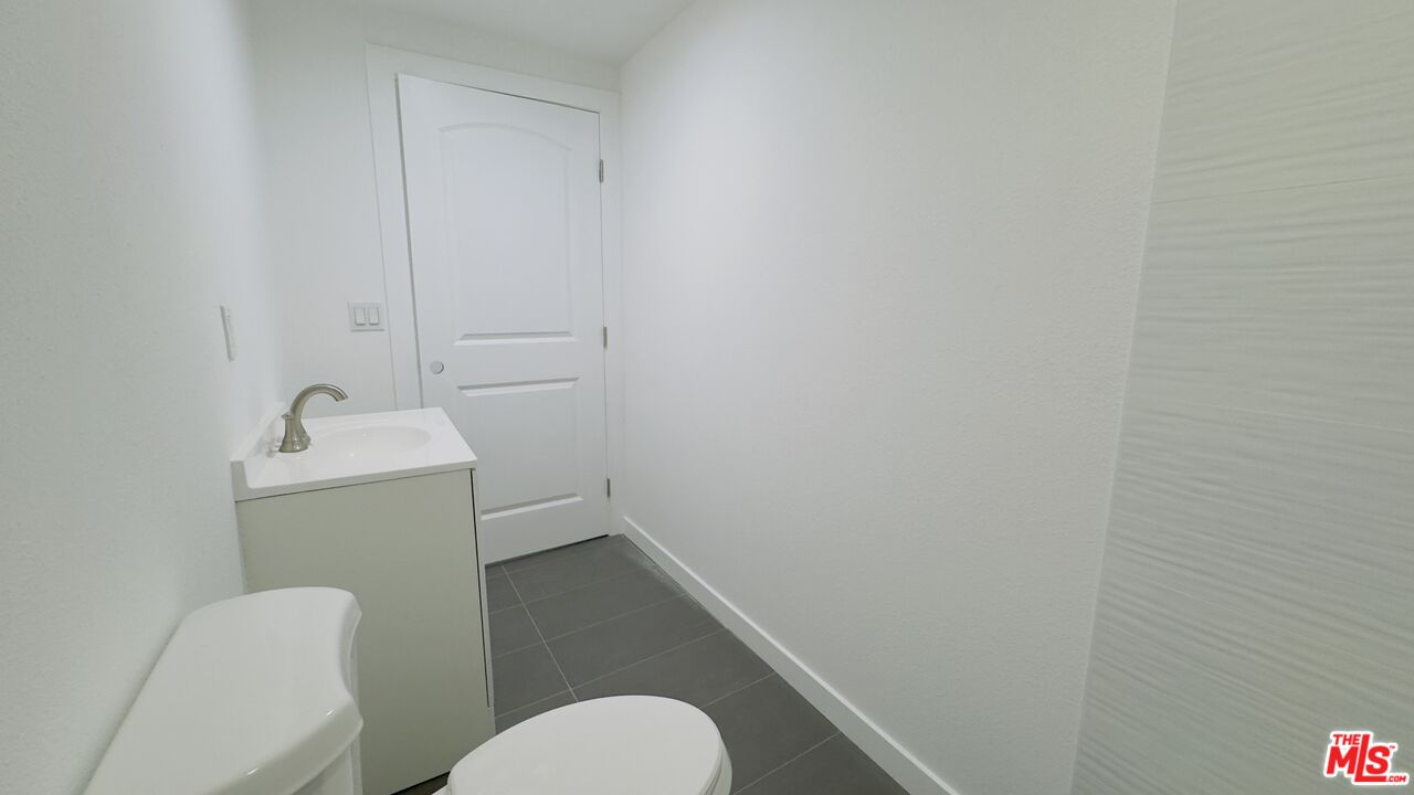 1732 Crenshaw Boulevard, Unit 1/3 Los Angeles, CA 90019 - Photo 6 of 6 a bathroom with a sink toilet and a mirror