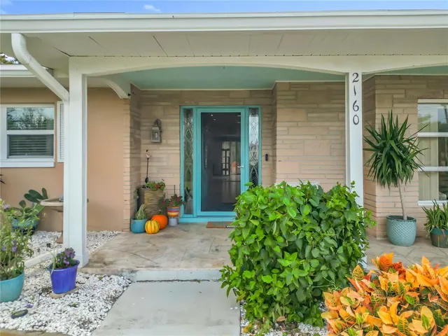 a vase of flowers sitting in front of a house