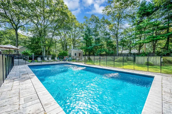 a view of house with a backyard and a bench