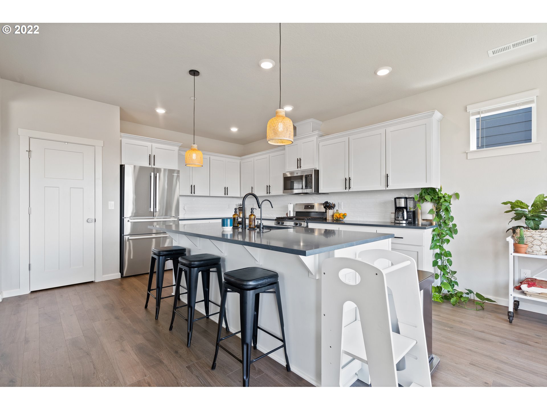 6690 North 89th Loop Camas, WA 98607 - Photo 7 of 24 a kitchen that has a lot of white cabinets and wooden floor