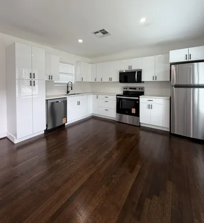 a kitchen with wooden floors and appliances