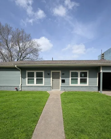 a front view of a house with a yard and potted plants
