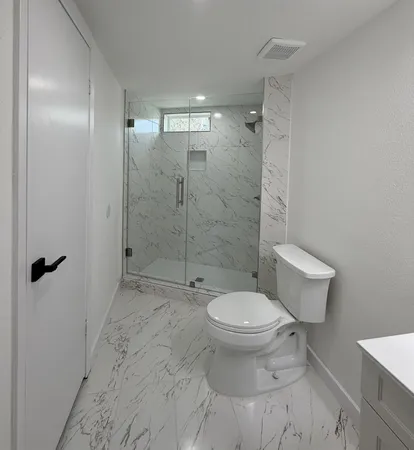 a bathroom with a toilet and a shower