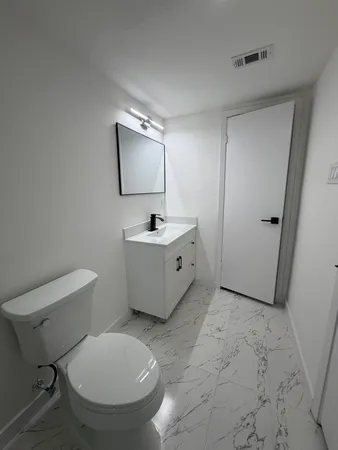 a bathroom with a toilet sink and mirror