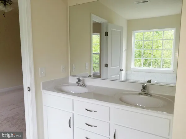 a bathroom with double sink and a mirror