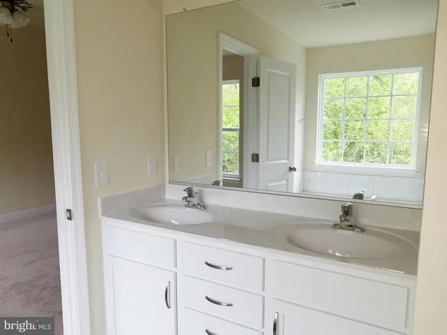 a bathroom with double sink and a mirror