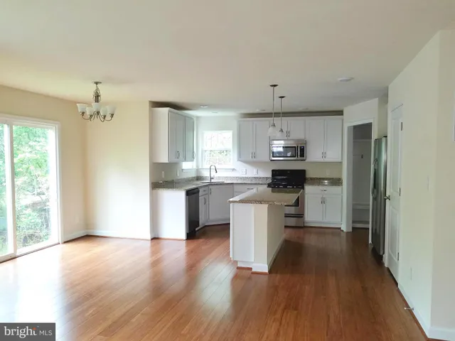 a kitchen with a refrigerator and a stove top oven