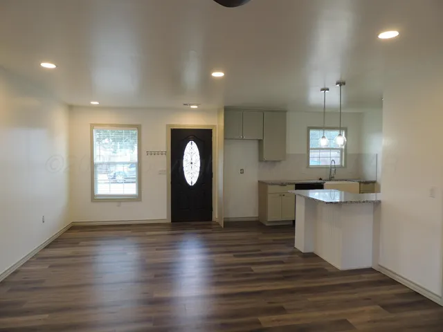 an empty room with wooden floor and window