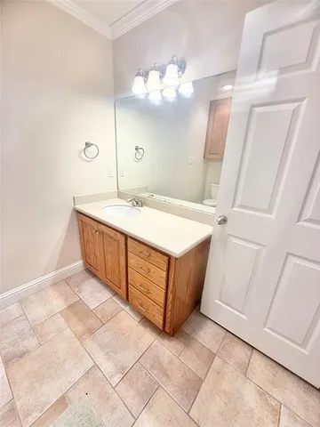 a room with a sink a chandelier and a mirror