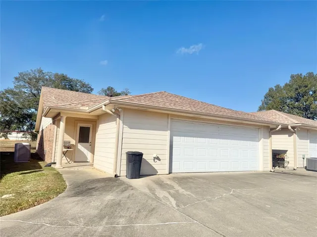 a view of a white house with a yard and large tree