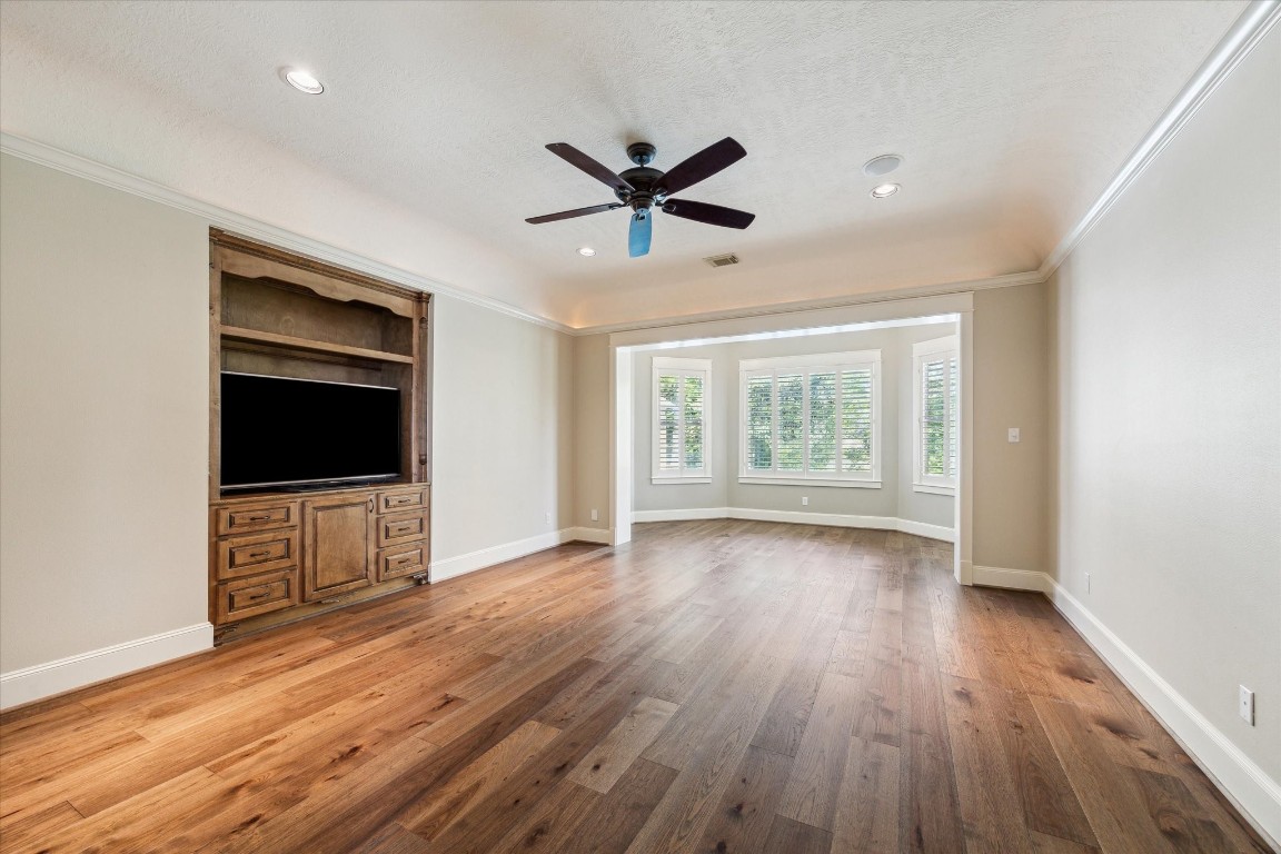 4511 Upper Oxbow Trace Fulshear, TX 77441 - Photo 13 of 40 an empty room with wooden floor fan and windows