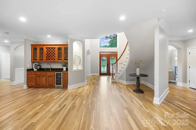 a kitchen with granite countertop a stove a sink a refrigerator and chairs