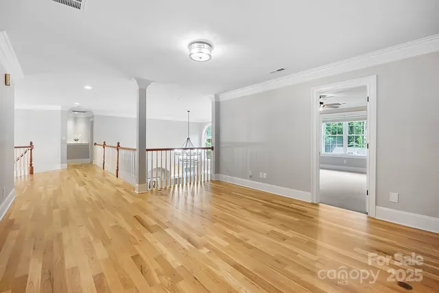 a spacious bedroom with a large bed and chandelier