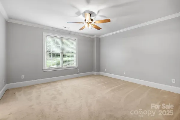 an empty room with a window and a fan