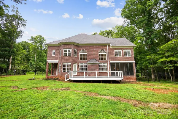 a front view of a house with a yard and trees