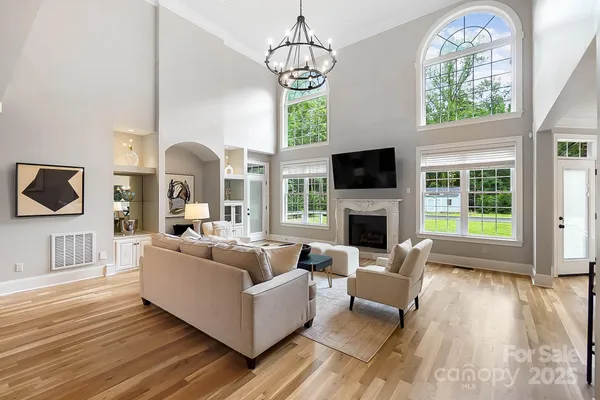 a living room with fireplace furniture and a large window