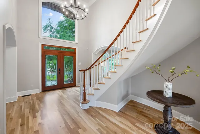 a open kitchen with granite countertop a stove a sink a dining table and chairs with wooden floor