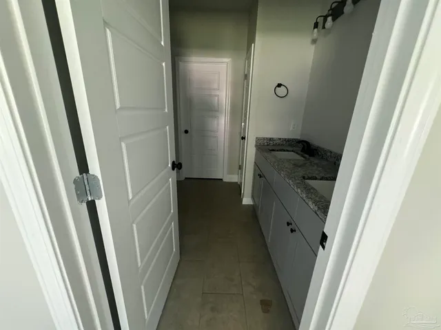 a bathroom with a granite countertop sink and a washer