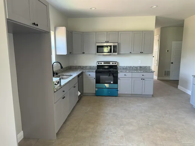 a kitchen with stainless steel appliances white cabinets and a refrigerator