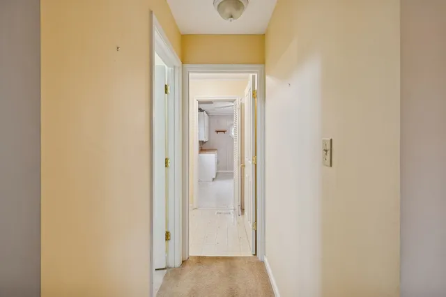 an empty room with windows and chandelier fan
