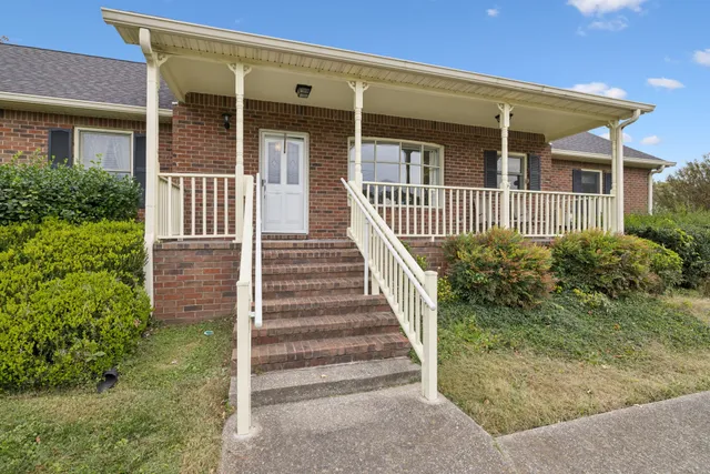 a view of a house with backyard and sitting area