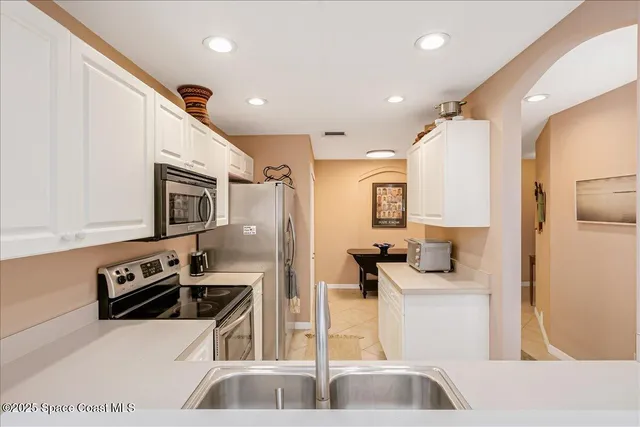 a kitchen with stainless steel appliances granite countertop a refrigerator sink and stove