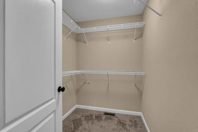 a view of walk in closet with clothes