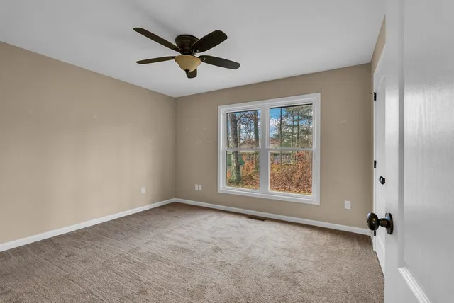 a view of a livingroom with a ceiling fan and window