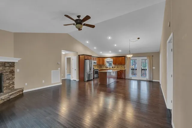 a view of empty room with wooden floor and fireplace