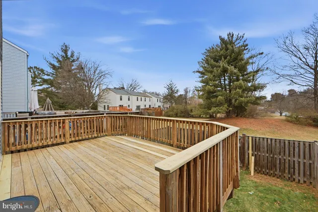a view of balcony with wooden floor and fence and trees