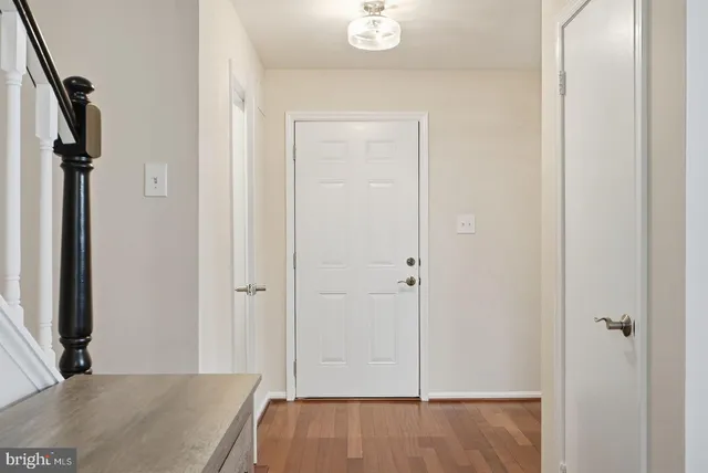 a view of a hallway with wooden floor and closet