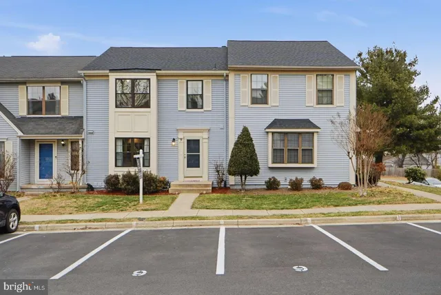a view of a white house with a large windows and a yard