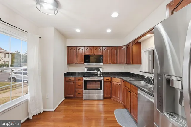 a kitchen with stainless steel appliances granite countertop a refrigerator stove and sink
